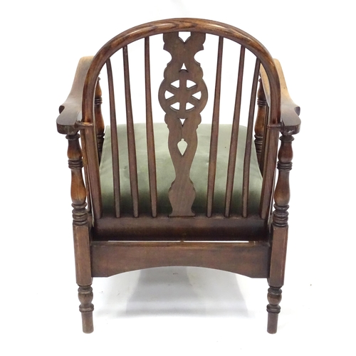 564 - A mid 20thC reclining wheelback armchair, of beech construction with upholstered seat, stamped '2157... 