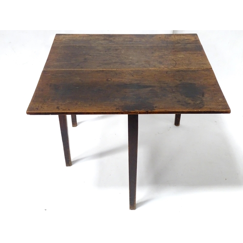 839 - A Georgian elm table with gate leg supporting a single leaf, the top approx 35