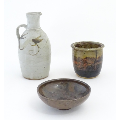 90 - Three items of studio pottery, comprising a jug with loop handle and brushwork decoration, a footed ... 