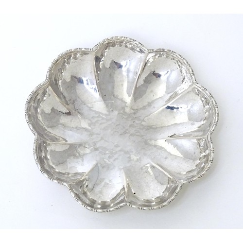 560 - A Continental .800 silver dish of lobed form with hammered decoration. Approx. 3 1/2