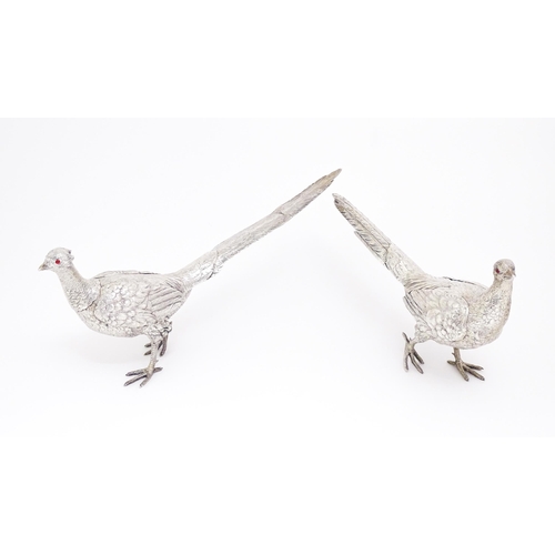 592 - A large pair of silver pheasants modelled as a cock and a hen pheasant with red glass eyes. Hallmark... 