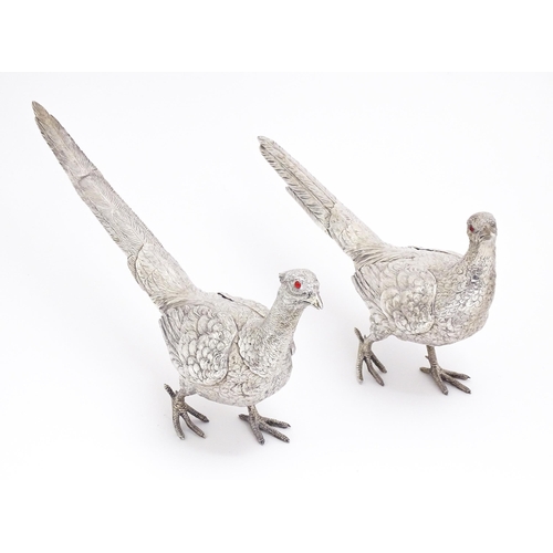 592 - A large pair of silver pheasants modelled as a cock and a hen pheasant with red glass eyes. Hallmark... 