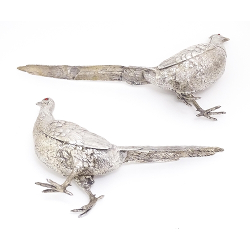 592 - A large pair of silver pheasants modelled as a cock and a hen pheasant with red glass eyes. Hallmark... 