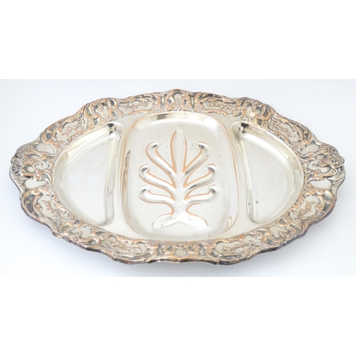 632 - A 19thC silver plate meat plate of oval form with tree and well detail to centre. Approx 17 1/2