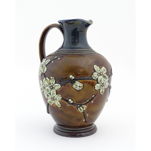 116 - A Doulton Lambeth jug with relief blossom detail. Marked under, with maker's mark for Kate Russell. ... 