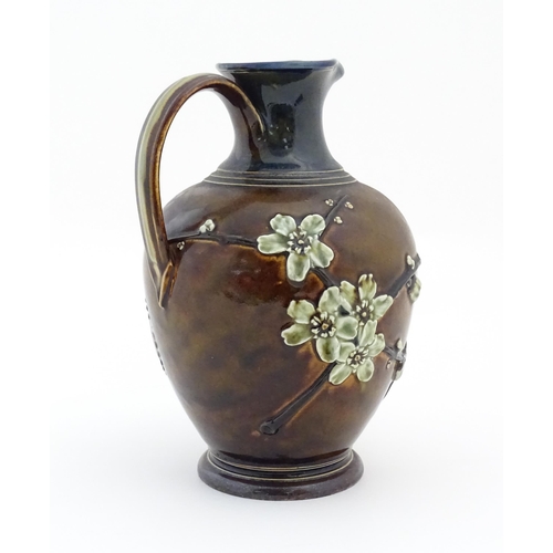 116 - A Doulton Lambeth jug with relief blossom detail. Marked under, with maker's mark for Kate Russell. ... 