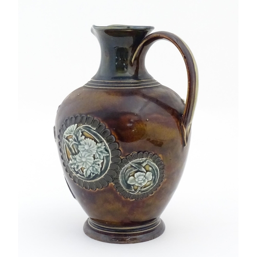 116 - A Doulton Lambeth jug with relief blossom detail. Marked under, with maker's mark for Kate Russell. ... 