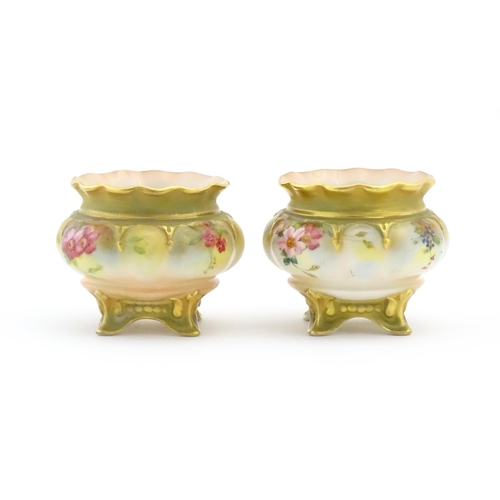 131 - Two Royal Worcester salts / pots with scalloped edge, swept feet and hand painted floral decoration.... 