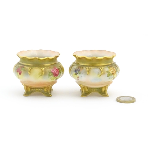 131 - Two Royal Worcester salts / pots with scalloped edge, swept feet and hand painted floral decoration.... 