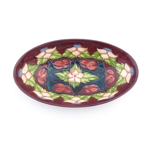 156 - Two items of Moorcroft comprising an oval dish decorated in the Morello pattern with flowers, foliag... 