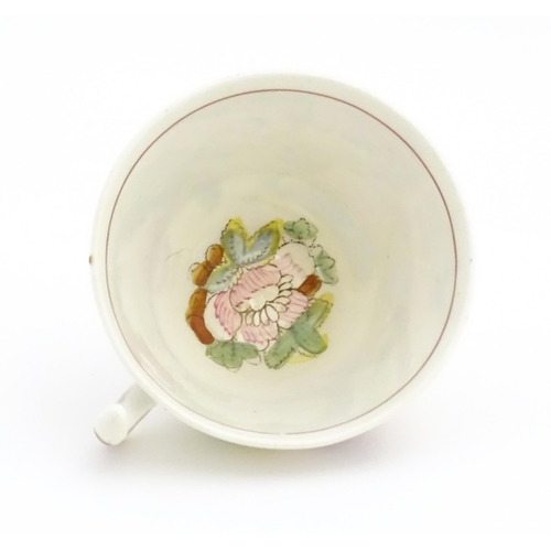 172 - A 19thC tea cup and saucer depicting figures by a fountain with flowers, birds and dog. In the manne... 