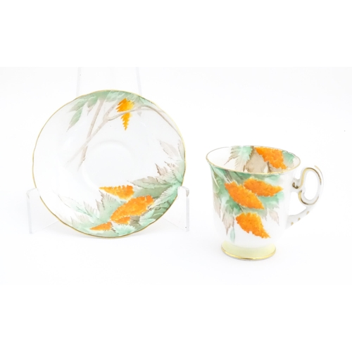 175 - An Art Deco Shelley cup and saucer decorated in the Orange Wisteria pattern. Marked under. Cup appro... 