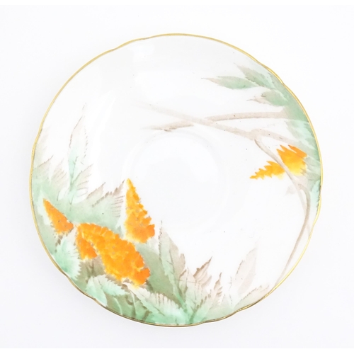 175 - An Art Deco Shelley cup and saucer decorated in the Orange Wisteria pattern. Marked under. Cup appro... 