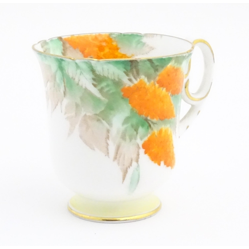 175 - An Art Deco Shelley cup and saucer decorated in the Orange Wisteria pattern. Marked under. Cup appro... 