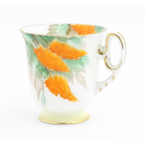 175 - An Art Deco Shelley cup and saucer decorated in the Orange Wisteria pattern. Marked under. Cup appro... 