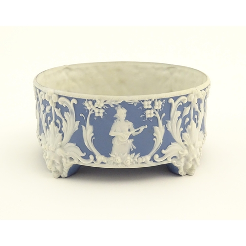 188 - A blue and white Jasperware style plant stand with relief Pan detail and scrolling foliage. Approx. ... 