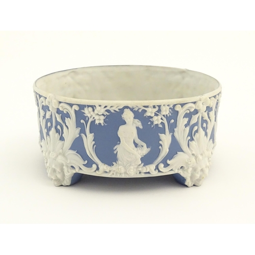 188 - A blue and white Jasperware style plant stand with relief Pan detail and scrolling foliage. Approx. ... 