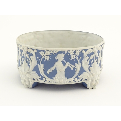 188 - A blue and white Jasperware style plant stand with relief Pan detail and scrolling foliage. Approx. ... 