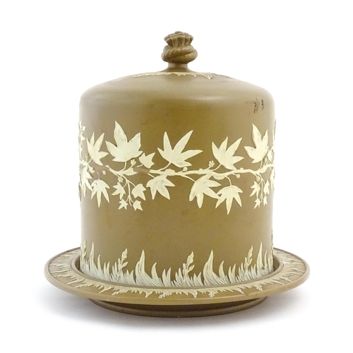 195 - A Wedgwood Jasperware style brown and white cheese dome with foliate decoration, the cover with hay ... 