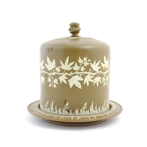 195 - A Wedgwood Jasperware style brown and white cheese dome with foliate decoration, the cover with hay ... 