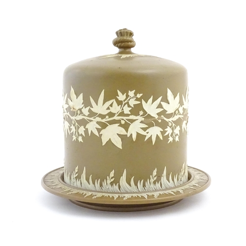 195 - A Wedgwood Jasperware style brown and white cheese dome with foliate decoration, the cover with hay ... 