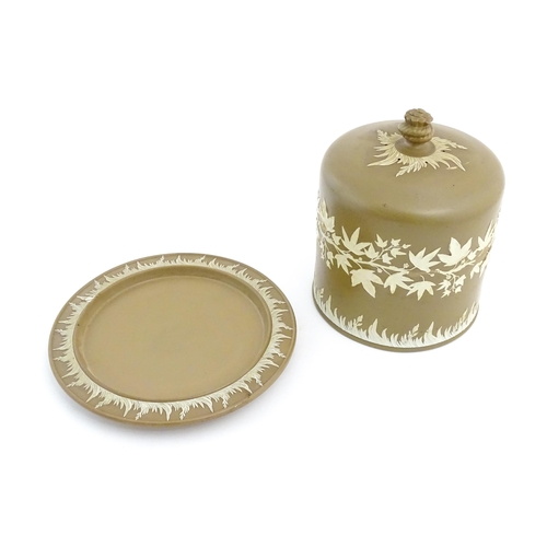 195 - A Wedgwood Jasperware style brown and white cheese dome with foliate decoration, the cover with hay ... 