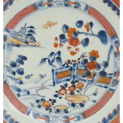 30 - A Chinese plate / dish of octagonal form decorated in the Imari palette depicting a garden terrace w... 