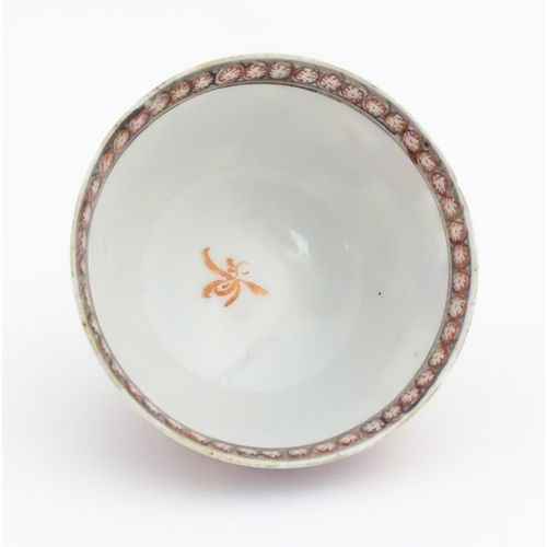 65 - A Miles Mason style tea bowl and saucer in the pattern Boy At Door, depicting Oriental figures in a ... 