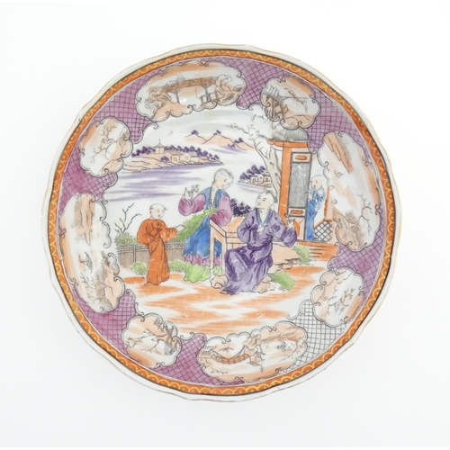 65 - A Miles Mason style tea bowl and saucer in the pattern Boy At Door, depicting Oriental figures in a ... 