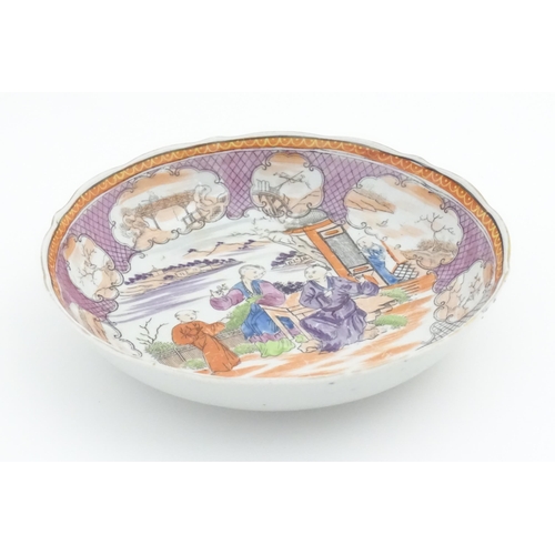 65 - A Miles Mason style tea bowl and saucer in the pattern Boy At Door, depicting Oriental figures in a ... 