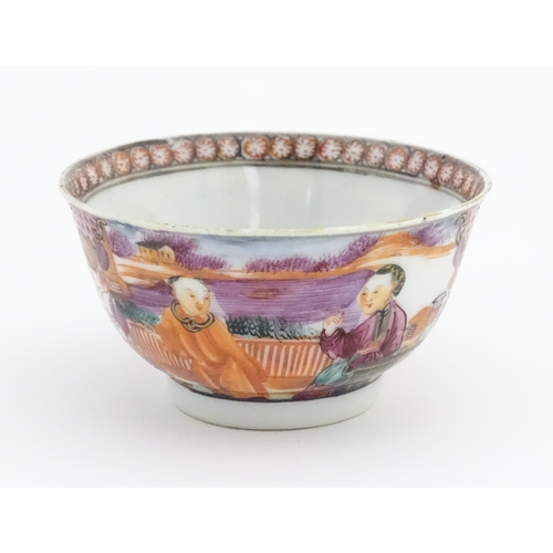 65 - A Miles Mason style tea bowl and saucer in the pattern Boy At Door, depicting Oriental figures in a ... 