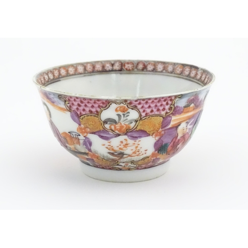 65 - A Miles Mason style tea bowl and saucer in the pattern Boy At Door, depicting Oriental figures in a ... 