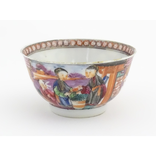 65 - A Miles Mason style tea bowl and saucer in the pattern Boy At Door, depicting Oriental figures in a ... 