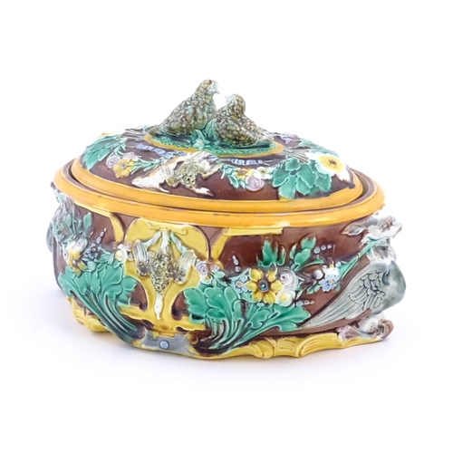 136 - A Victorian majolica game pie dish and cover, the body decorated in relief with birds, flowers and f... 