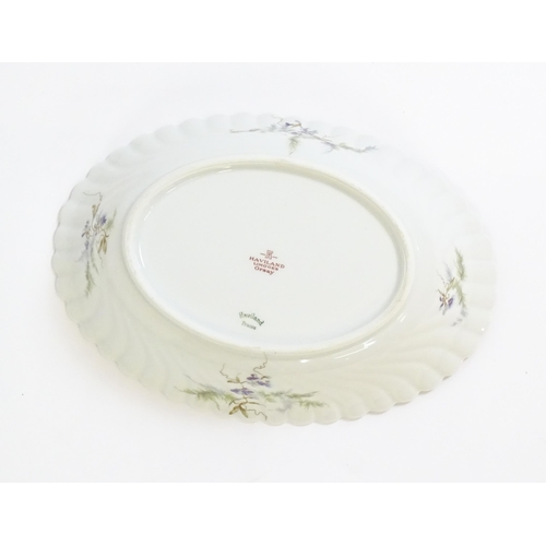 203 - A quantity of Haviland Limoges dinner wares in the Orsay pattern to include plates, serving dishes, ... 