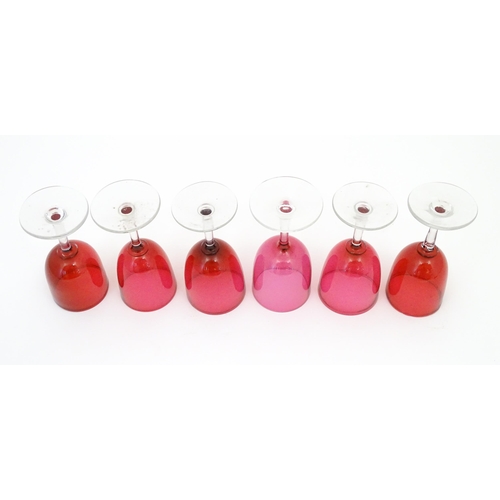 224 - Six assorted cranberry glass drinking glasses, with cranberry coloured bowls and clear glass stem an... 