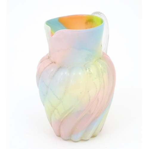 231 - A glass jug with pink, yellow blue and orange swirl detail , with clear loop handle.  Approx 8 1/2