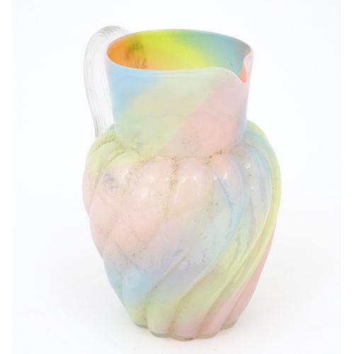 231 - A glass jug with pink, yellow blue and orange swirl detail , with clear loop handle.  Approx 8 1/2