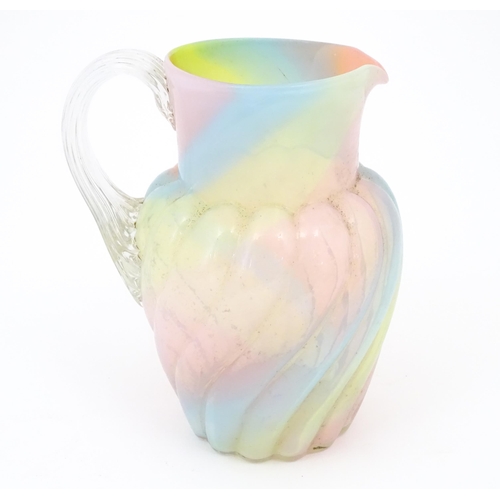 231 - A glass jug with pink, yellow blue and orange swirl detail , with clear loop handle.  Approx 8 1/2