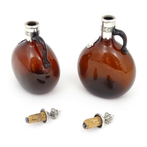 235 - Two 19thC amber glass flasks / decanters with silver plate mounts. Largest approx 9