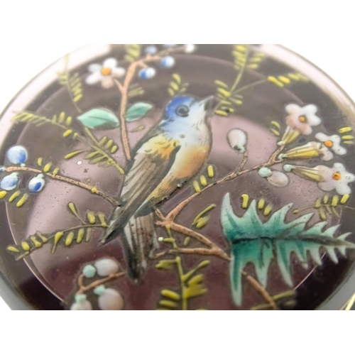 238 - An amethyst coloured glass pot with hinged top having an painted scene of a bird amongst branches. A... 