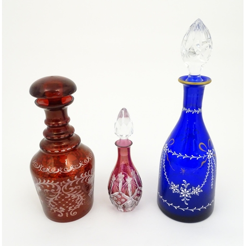 250 - Three assorted glass decanters to include ruby, blue and cranberry coloured examples. The largest ap... 