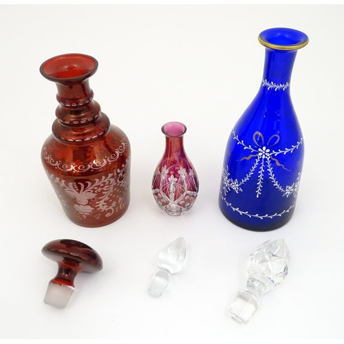 250 - Three assorted glass decanters to include ruby, blue and cranberry coloured examples. The largest ap... 