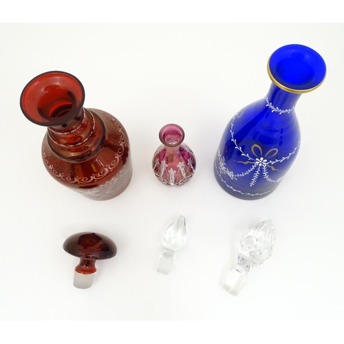 250 - Three assorted glass decanters to include ruby, blue and cranberry coloured examples. The largest ap... 