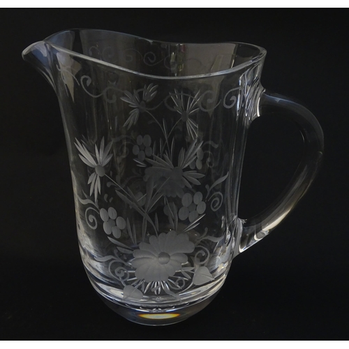 251 - A glass water jug and 6 glasses with engraved floral detail. The Jug approx 7 1/4