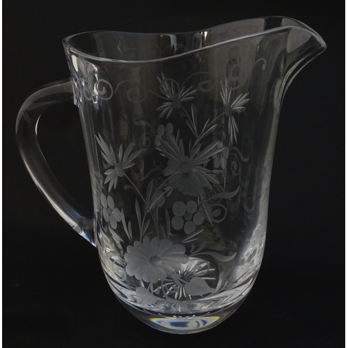 251 - A glass water jug and 6 glasses with engraved floral detail. The Jug approx 7 1/4