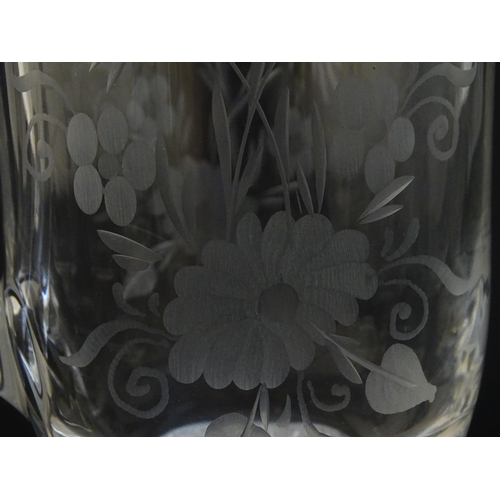 251 - A glass water jug and 6 glasses with engraved floral detail. The Jug approx 7 1/4