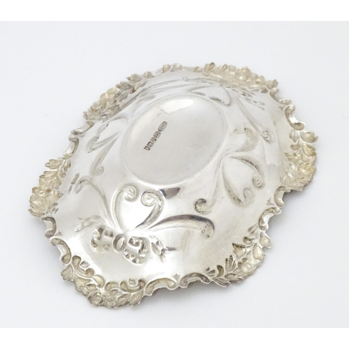 264 - A silver bonbon dish of oval form with embossed decoration, hallmarked Birmingham 2002 with Elizabet... 