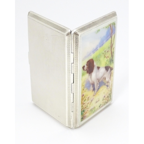 275 - An Art Deco silver cigarette case with enamel Spaniel dog decoration, engine turned detail and gilde... 