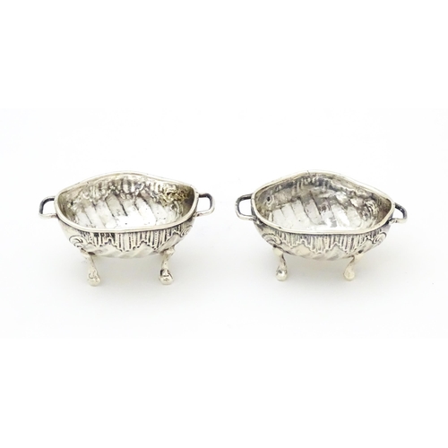 279 - A pair of Continental .930 silver salts with  engraved decoration and twin handles raised on four fe... 